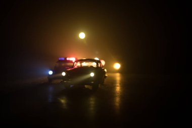 Polis arabası sisli bir arabayı gece takip ediyor. 911 acil durum arabası suç mahalline doğru hızla gidiyor. Seçici odak
