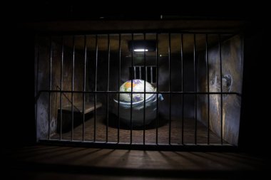 Corona virüsü yaratıcı konsepti kilitledi. Dünya gezegeni eski hapishanenin içinde kapana kısıldı. Yaratıcı sanat dekorasyonu. Seçici odak