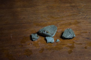 Tahta bir masanın üzerinde kırık taş parçaları. Seçici odak noktasında taşların üzerindeki renkli ışıklar. Kapat.