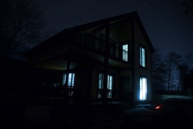 Sisli bir gecede ormanda bir hayaletin olduğu eski bir ev ya da House 'un ayın altında olduğu bir gece sahnesi. Ölü ağaç ormanındaki eski mistik bina..