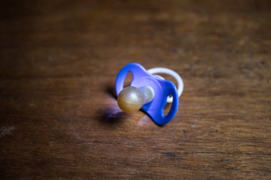 Bebek emziği ahşap masada, arka planda düşük tonlu. Seçici odak