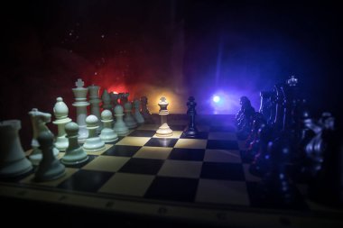 Satranç tahtasındaki güzel kraliçe ve kral tacı. Satranç masası iş fikirleri, rekabet ve strateji fikirleri konsepti. Duman ve sisli karanlık bir arka planda satranç figürleri. Seçici odak