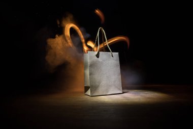 Alışveriş konsepti. Koyu renk masaüstüne saplı kahverengi alışveriş çantası. Seçici odak