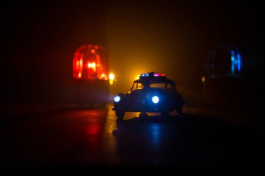 Polis arabası sisli bir arabayı gece takip ediyor. 911 acil durum arabası suç mahalline doğru hızla gidiyor. Yaratıcı dekorasyon. Seçici odak