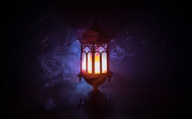 İslami bayram için gece mumlu Arap feneri. Müslüman kutsal Ramazan ayı. Bayram ve Mutlu Yıllar 'ın sonu. Boşluğu koyu arkaplanda kopyala.