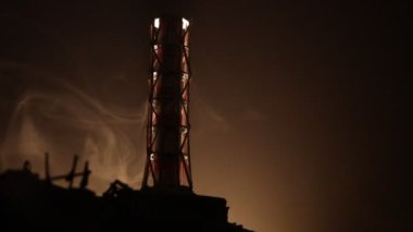 Karanlık arka planda, patlamanın mistik ışığıyla nükleer santral borusu, Çernobil felaketi konsepti