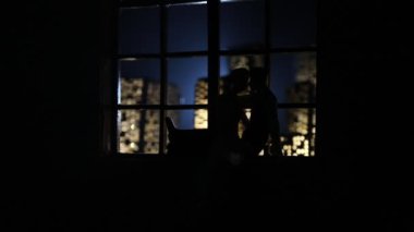 Çizgi film tarzı şehir binaları ön planda çift var.