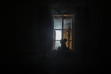 Dollhouse 'un penceresinden gece minyatür bir şehrin güzel manzarası. Pencerede romantik bir çift. El yapımı gerçekçi bebek eviyle sanat masası dekorasyonu. Seçici odak.