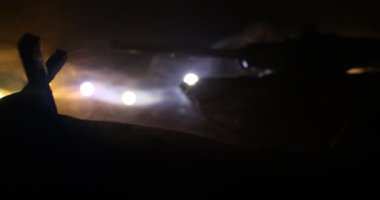 Zırhlı araç siluetinin savaş sisli arka planındaki savaş sahnesinin gece görüntüleri.