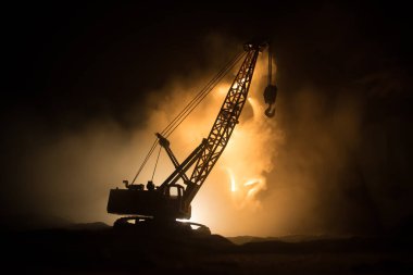 Yapı vinç silueti ile soyut endüstriyel arka plan sisli ve arka planda muhteşem gece gökyüzü üzerinde. Gece sisli gökyüzüne karşı kule vinci. Endüstriyel gökyüzü. Seçici odak
