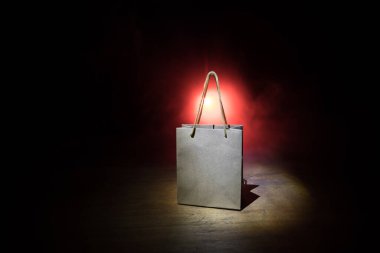 Alışveriş konsepti. Koyu renk masaüstüne saplı kahverengi alışveriş çantası. Seçici odak