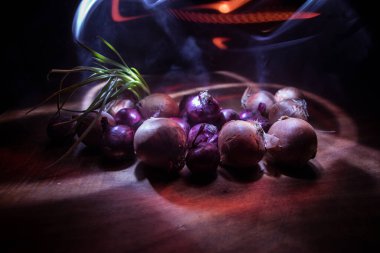 Sebze konsepti. Karanlıkta farklı soğanlar. Seçici odaklanma. Renkli arkaplan.