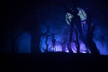 Kana susamış zombiler konsepte saldırıyor. Geceleri ölü ormanda yürüyen korkunç zombi silueti. Yaratıcı masa dekorasyonları. Seçici odak