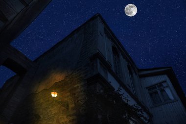 Geceleri eski şehir sokakları. Gece şehrin üzerinde dolunay var, Bakü Azerbaycan. Büyük dolunay binaların üzerinde parlıyor.