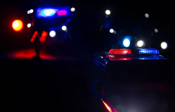 Police cars at night. Police car chasing a car at night with fog background. 911 Emergency response police car speeding to scene of crime. Selective focus