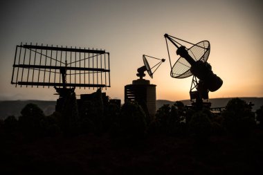 Günbatımında uzay radar anteni. Uydu anteni siluetleri ya da gece gökyüzüne karşı radyo antenleri. Yaratıcı sanat dekorasyonu. Seçici odak