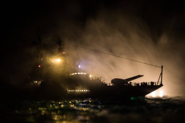 Savaş konsepti. Denizde gece savaşı sahnesi. Dramatik tonlu bulut etkisi. Gece savaş gemisinin silueti. Minyatür yaratıcı masa dekorasyonu. Seçici odak