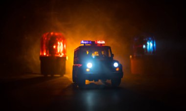Polis arabası sisli bir arabayı gece takip ediyor. 911 acil durum arabası suç mahalline doğru hızla gidiyor. Yaratıcı dekorasyon. Seçici odak