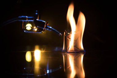 Yaratıcı bir kavram. Koyu tonlu sisli arka planda benzin tabancası minyatürü. Kapatın. Arka planda endüstriyel unsurlar var. Seçici odak