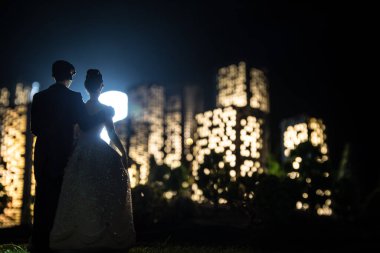 Çizgi film tarzı şehir binaları. Gerçekçi şehir ışıklarla minyatürler inşa ediyor. Geçmişi. Zenci şehrinin seçici odak noktasında duran romantik çift siluetleri
