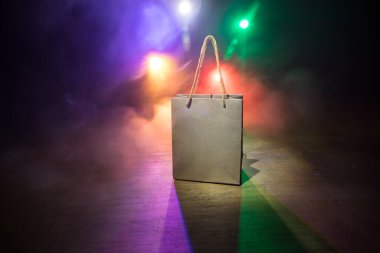 Alışveriş konsepti. Koyu renk masaüstüne saplı kahverengi alışveriş çantası. Seçici odak