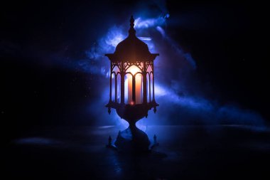 İslami bayram için gece mumlu Arap feneri. Müslüman kutsal Ramazan ayı. Bayram ve Mutlu Yıllar 'ın sonu. Boşluğu koyu arkaplanda kopyala.