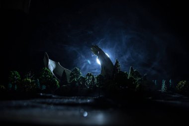 Soyut sürrealite kavramı. Karanlık ormanda ay ışığı altında dev bir hayvan kemiği. Gece sisli ve arka planda ışık var. Seçici odak