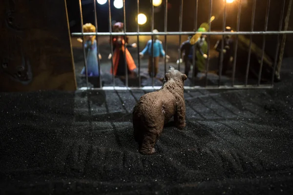 People and animals on opposite sides of the fence concept. Creative decoration with toy figures. Burning colorful background. Selective focus.