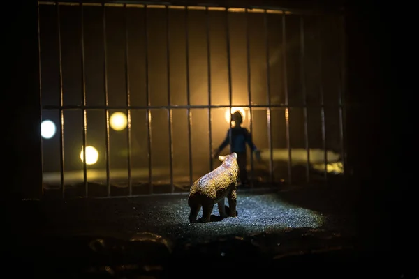 People and animals on opposite sides of the fence concept. Creative decoration with toy figures. Burning colorful background. Selective focus.