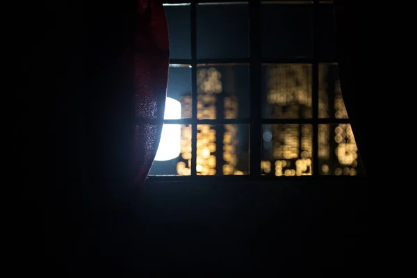 look through a window and city night view. Realistic dollhouse window and city miniature in selective focus.