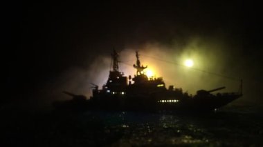 Savaş konsepti. Denizde gece savaşı sahnesi. Dramatik tonlu bulut etkisi. Gece savaş gemisinin silueti. Minyatür yaratıcı masa dekorasyonu. Seçici odak