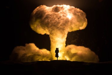 Nükleer savaş konsepti. Nükleer bomba patlaması. Karanlıkta yaratıcı sanat dekorasyonu. Anne ve çocuğu dev atom patlaması mantar bulutuna karşı. Seçici odak