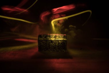 Ahşap masaya kapağı kapatılmış koyu tahta bir hazine sandığı. Seçici odak