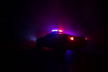 Polis arabası sisli bir arabayı gece takip ediyor. 911 acil durum arabası suç mahalline doğru hızla gidiyor. Yaratıcı dekorasyon. Seçici odak