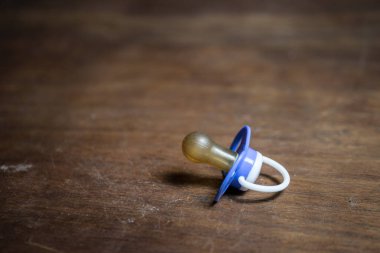 Bebek emziği ahşap masada, arka planda düşük tonlu. Seçici odak