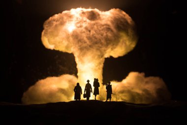 Nuclear war concept. Explosion of nuclear bomb. Creative artwork decoration in dark. People looking on giant mushroom cloud of atomic explosion. Selective focus clipart