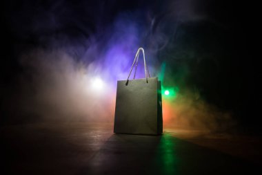 Alışveriş konsepti. Koyu renk masaüstüne saplı kahverengi alışveriş çantası. Seçici odak