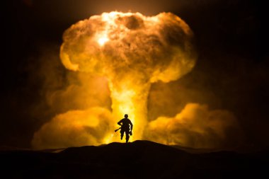 Nükleer savaş konsepti. Nükleer bomba patlaması. Karanlıkta yaratıcı sanat dekorasyonu. Atomik patlamanın dev mantar bulutuna karşı duran asker silueti. Seçici odak