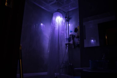 Cadılar Bayramı konsepti Duş kabinindeki korkunç insan silueti. Parlayan ışıkları olan katil manyak banyoda. Uzun pozlama