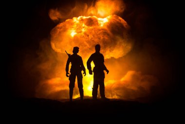 Nükleer savaş konsepti. Nükleer bomba patlaması. Karanlıkta yaratıcı sanat dekorasyonu. Atomik patlamanın dev mantar bulutuna karşı duran asker siluetleri. Seçici odak