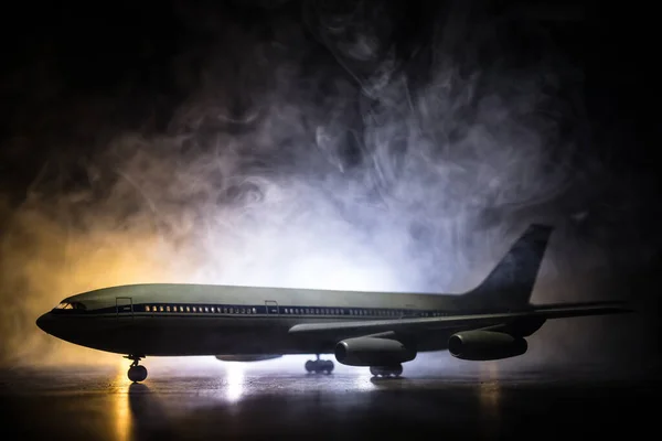 Artwork decoration. White passenger plane ready to taking off from airport runway. Silhouette of Aircraft during night time. Selective focus