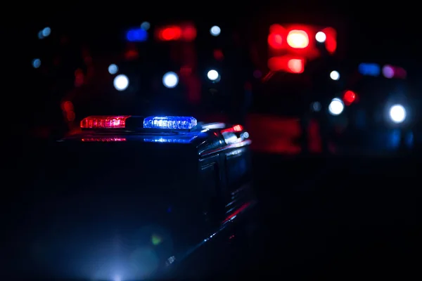 Police cars at night. Police car chasing a car at night with fog background. 911 Emergency response police car speeding to scene of crime. Selective focus