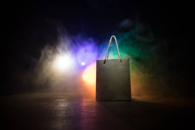 Alışveriş konsepti. Koyu renk masaüstüne saplı kahverengi alışveriş çantası. Seçici odak