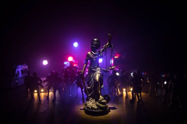 Kanun ya da diktatörlük kavramı yok. İsyan karşıtı polis miğferi tutan Adalet Anıtı. Renkli sisli arka planlı yaratıcı sanat dekorasyonu. Seçici odak