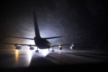 Sanat dekorasyonu. Beyaz yolcu uçağı havaalanından kalkmaya hazır. Gece vakti uçağın silueti. Seçici odak