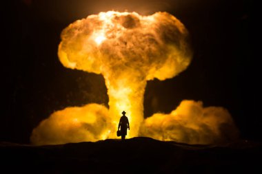 Nükleer savaş konsepti. Nükleer bomba patlaması. Karanlıkta yaratıcı sanat dekorasyonu. Bir insanın siluetine karşı dev mantar bulutu atomik patlama. Seçici odak