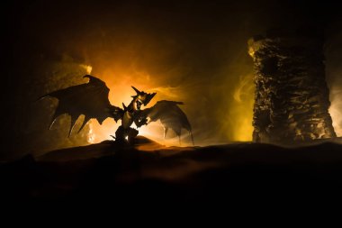 Geceleri ejderhaların bir ortaçağ kalesine saldırdığı fantezi savaş sahnesi. Ejderha ve kahraman askerler arasındaki savaş. Yaratıcı masa dekorasyonu. Seçici odak