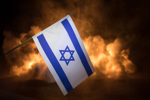 以色列小国旗在燃烧的黑暗背景 战争危机和国家间政治冲突的概念 有选择的重点 — 图库照片