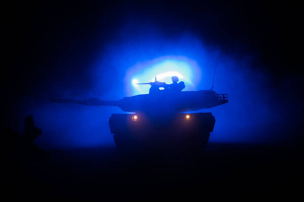 War Concept. Armored vehicle silhouette fighting scene on war foggy sky background at night. American tank ready to fight. Creative decoration