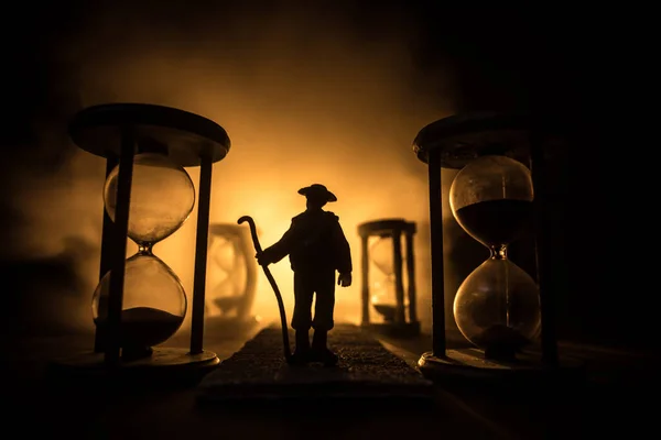 Koncepcja Czasu Sylwetka Mężczyzny Stojącego Między Klepsydrami Dymem Światłami Ciemnym — Zdjęcie stockowe